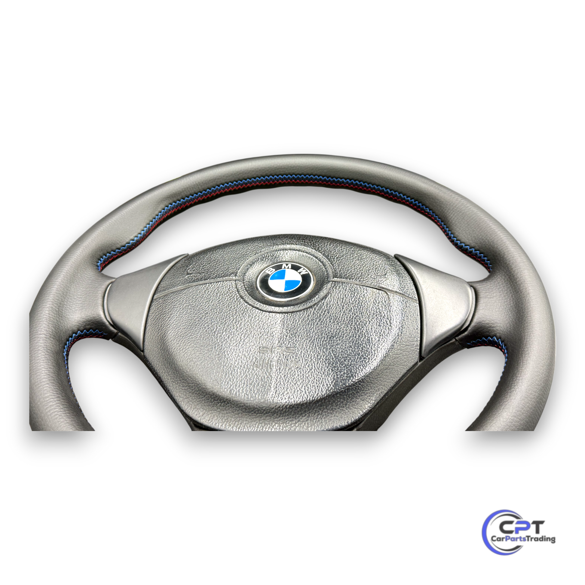 Detailaufnahme: M-Ziernaht auf schwarzem Leder am unteren Bereich des Lenkrads

